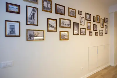 a wall of pictures on a white wall at Nomad Haux Zaidia in Valencia