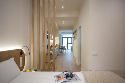 a bedroom with a bed and a hallway with a kitchen at Nomad Haux Zaidia in Valencia
