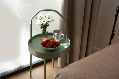 a table with a bowl of fruit and a vase of flowers at Nomad Haux Zaidia in Valencia