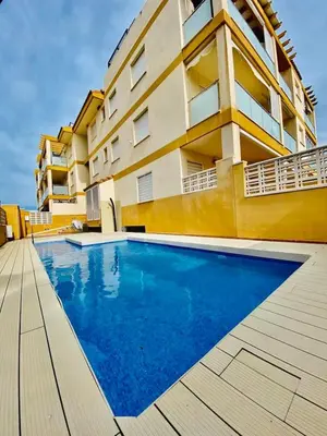 a swimming pool in front of a building at Puzol beach penthouse in Playa de Mar