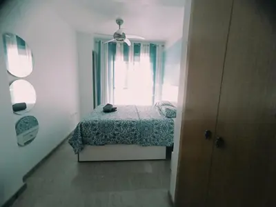 a small bedroom with a bed and a window at Puzol beach penthouse in Playa de Mar