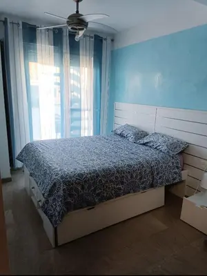 a bedroom with a bed and a ceiling fan at Puzol beach penthouse in Playa de Mar