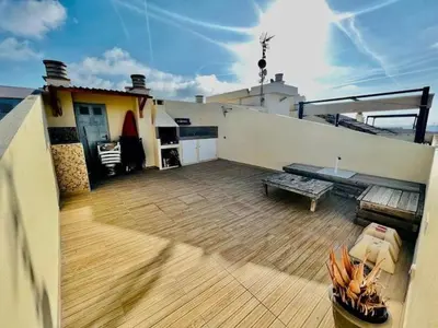 a balcony of a house with a bench and a table at Puzol beach penthouse in Playa de Mar