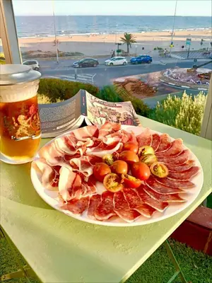 a plate of food sitting on a table with a drink at ESPECIAL FALLAS 25 MINUTOS VALENCIA PLAYA in Puerto de Sagunto