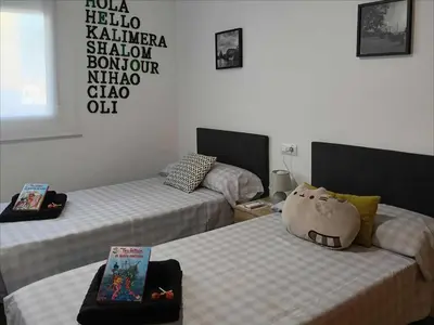a room with two beds and a pillow on the bed at ESPECIAL FALLAS 25 MINUTOS VALENCIA 6 PLAZAS in Puerto de Sagunto