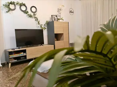 a living room with a flat screen tv at ESPECIAL FALLAS 25 MINUTOS VALENCIA 6 PLAZAS in Puerto de Sagunto