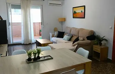 a living room with a table and a couch at ESPECIAL FALLAS 25 MINUTOS VALENCIA 6 PLAZAS in Puerto de Sagunto