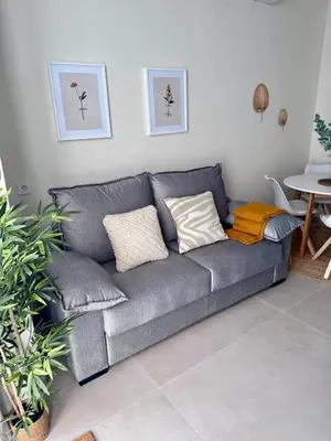 a gray couch with pillows in a living room at Apartamento Boutique Valencia 4-Pax - A-1 in Valencia