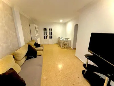 a living room with a couch and a flat screen tv at Habitaciones en Apartamento Port Sagunto in Puerto de Sagunto