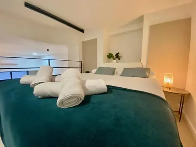 a bedroom with a large bed with towels on it at Duplex City of Arts & Science in Valencia