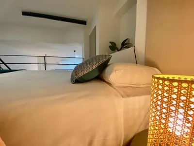 a bedroom with a bed with two pillows and a lamp at Duplex City of Arts & Science in Valencia