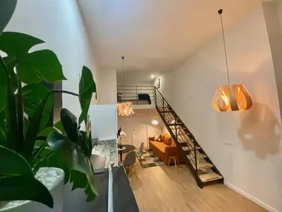 a living room with a staircase and a couch at Duplex City of Arts & Science in Valencia