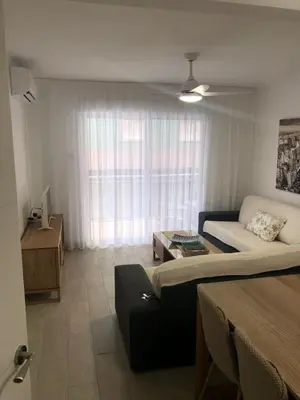 a living room with a bed and a couch at Apartamento con vistas a la playa in El Perelló