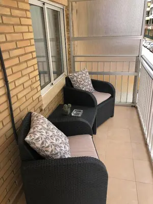 a balcony with two chairs and a table at Apartamento con vistas a la playa in El Perelló