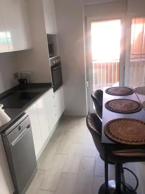 a kitchen with a table and two stools in it at Apartamento con vistas a la playa in El Perelló