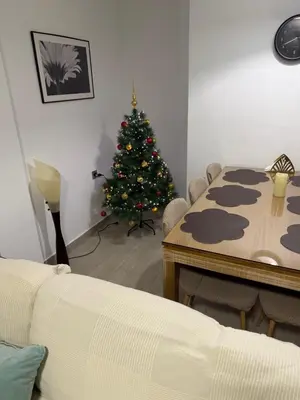 a living room with a christmas tree and a table at Apartamento con vistas a la playa in El Perelló