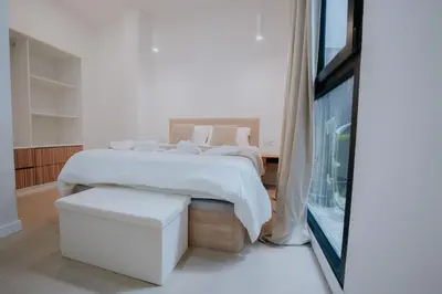 a white bedroom with a bed and a window at Room Turia in Valencia