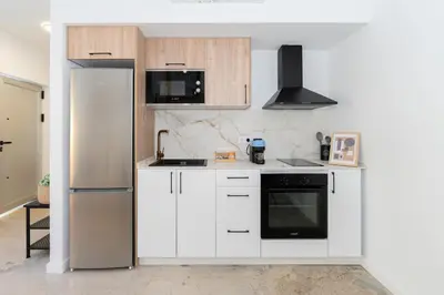 a kitchen with white cabinets and a black appliance at Casa Ambrosia in Valencia