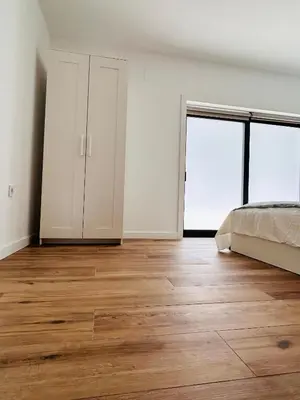 an empty bedroom with a bed and wooden floors at Aires de Valencia in Valencia