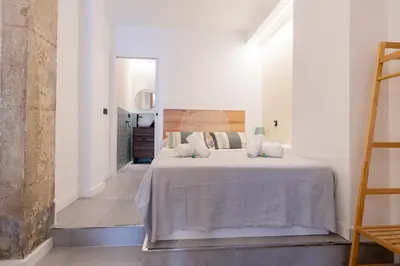 a bedroom with a large bed with white sheets and pillows at Blue City Apartments in Valencia