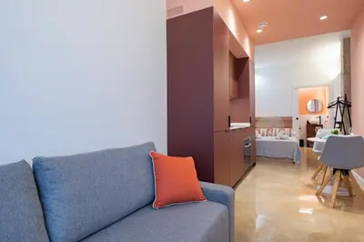 a living room with a blue couch with an orange pillow at Blue City Apartments in Valencia