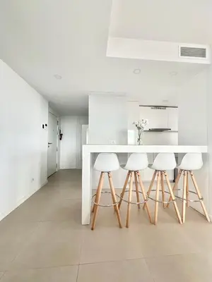 a kitchen with a white table and four stools at Luxury Canet in Canet de Berenguer