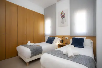 a hotel room with two beds and a cabinet at SingularStays Mar44 Terrace in Valencia