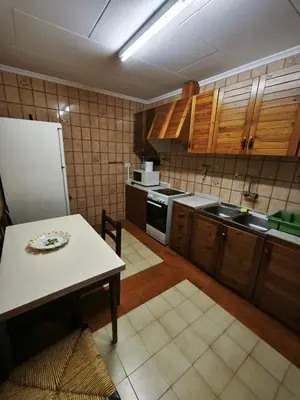 a kitchen with a table and a white refrigerator at Casa Numari in Caudiel