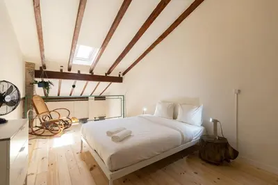 a bedroom with a large white bed with a wooden floor at Apartamento2 para 4 huespedes con Patio y ducha Exterior in Valencia