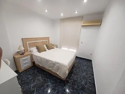 a small bedroom with a bed and a night stand at piso tres habitaciones in Valencia