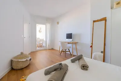 a white bedroom with a bed and a desk at Seaview Apartment in Canet with Rooftop Pool in Canet de Berenguer