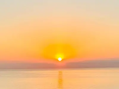 a sunset over the ocean with the sun in the sky at Seaview Apartment in Canet with Rooftop Pool in Canet de Berenguer