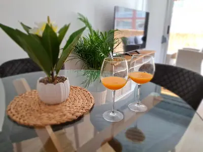 two glasses of orange juice on a glass table at Cullera Mar Azul in Cullera