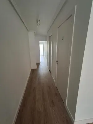 an empty hallway with white walls and wood floors at Cullera Mar Azul in Cullera