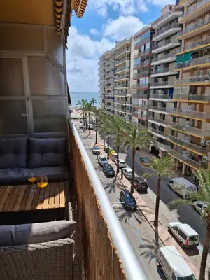 a balcony of a building with palm trees and buildings at Cullera Mar Azul in Cullera
