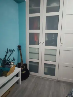 a room with white closet doors and a guitar at Vacansis Cullera Pintor Sorolla 2 in Cullera