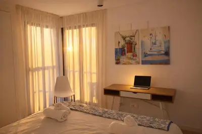 a bedroom with a bed and a laptop on a desk at Valencia Beach Home 21 in Valencia