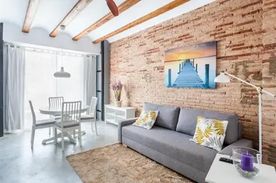 a living room with a couch and a brick wall at Ruzafa Confort 3 pax wifi Denia 70 in Valencia