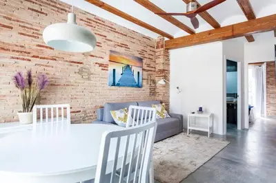 a living room with a white table and a brick wall at Ruzafa Confort 3 pax wifi Denia 70 in Valencia