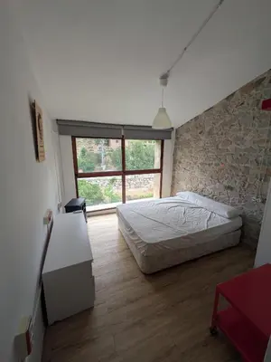 a bedroom with a bed and a stone wall at Casa rural El Mestre in Alcudia de Veo