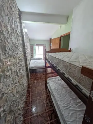 a room with two beds and a stone wall at Casa rural El Mestre in Alcudia de Veo