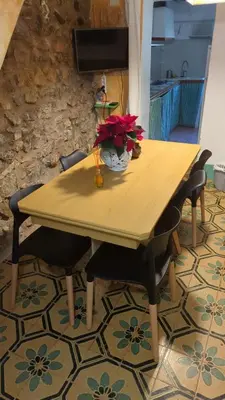 a wooden table with chairs and a vase of flowers on it at Casa rural El Mestre in Alcudia de Veo