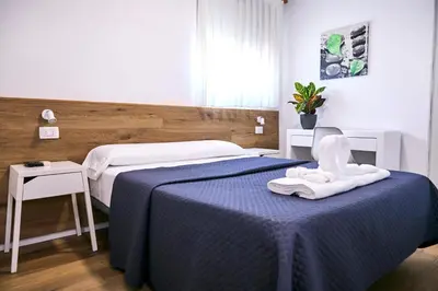 a bedroom with a blue bed with towels on it at V Pension & Suites in Burriana