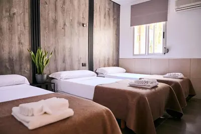 a room with four beds with towels on them at V Pension & Suites in Burriana