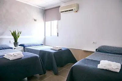 a room with two beds and two tables with towels at V Pension & Suites in Burriana