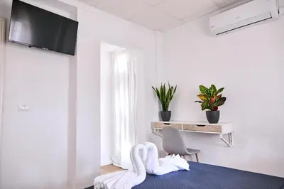 a white room with two white towels on a bed at V Pension & Suites in Burriana