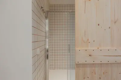 a bathroom with a shower with a tiled wall at Travel Habitat Playa del Cabanyal in Valencia
