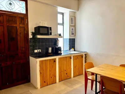 a kitchen with a table and a microwave at Travel Habitat Playa del Cabanyal in Valencia