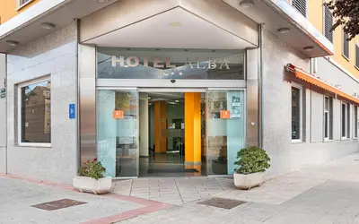 a store front of a building with two plants at Hotel Alba in Puzol