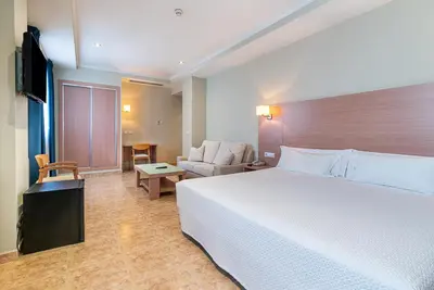 a hotel room with a large bed and a couch at Hotel Alba in Puzol
